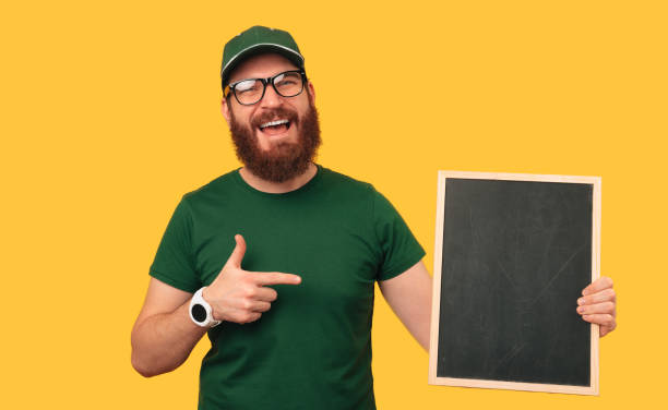 istock Bearded man holding a blank black board with copy space and a thumb up. 1487482511