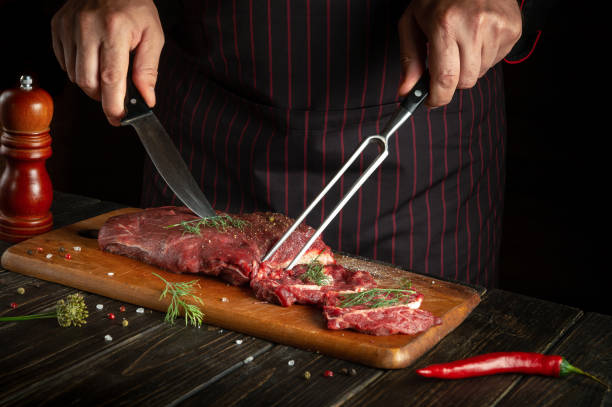 istock Butcher or chef preparing raw fresh beef meat on cutting board before baking or barbecue. Recipe idea for a restaurant or hotel 1487486770