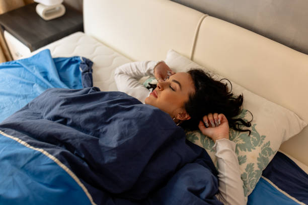 istock A young beautiful brunette is sleeping in a comfortable bed. 1487487101