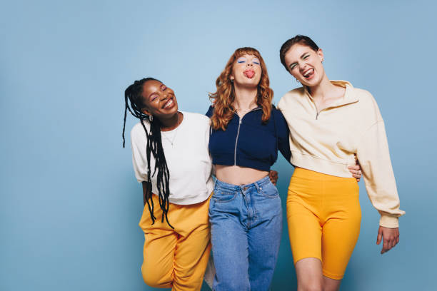 istock Cheerful female friends making funny faces while standing together in a studio 1487491830