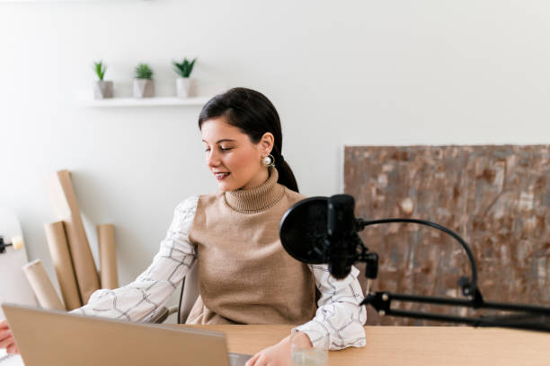 istock Young smiling women recording podcast and doing live streaming using microphone and headphones in recording studio 1487493518