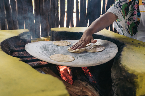 Authentic Mexican handmade tortillas in a traditional rustic wood stove called 