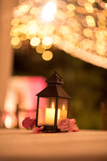 istock Candle lantern table decoration with bokeh lights in background 1487494236