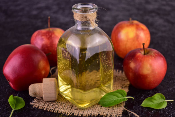 istock Apple cider vinegar and fresh apple on a black background. 1487494365