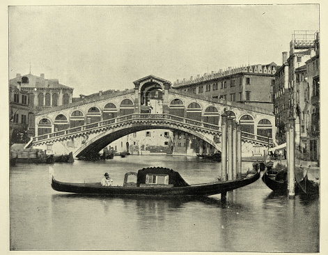 Traditional gondola in front of Rialto Bridge, Ponte di Rialto, the oldest of the four bridges spanning the Grand Canal in Venice, Italy 19th Century