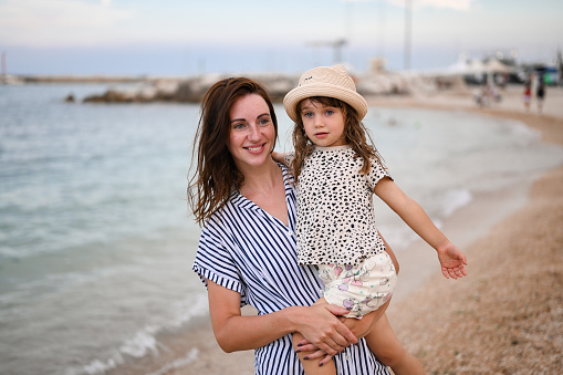 little  cute daughter spending time together at the seaside in Italy