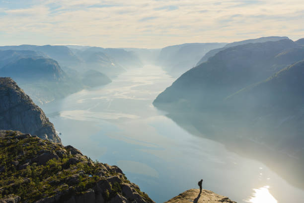 istock Woman standing on Preikestolen and looking at view 1487498081