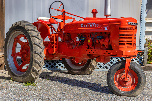 Bryson, North Carolina, USA - April 19, 2023: Downtown behind the train station sits an old Farmall Tractor.