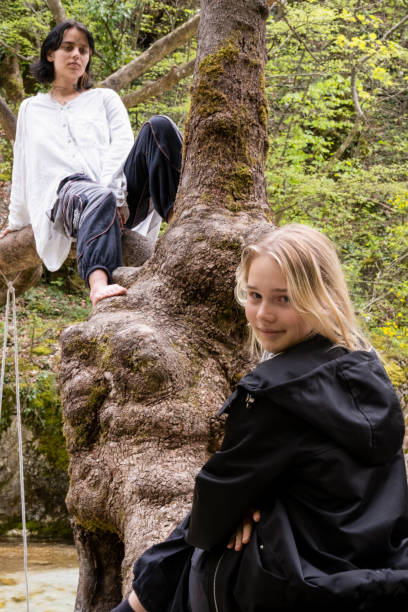 istock two girls in black and white clothes sitting on a tree 1487500809