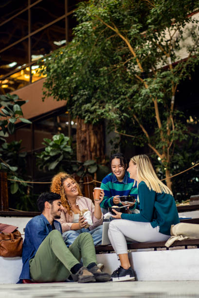 Group of student siting in campus having lunch brake. stock photo