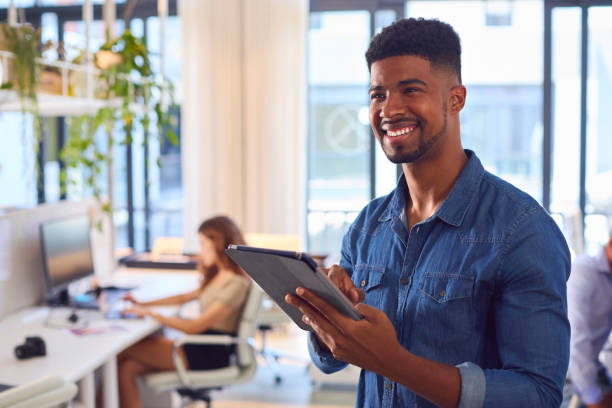 istock Young Smiling Businessman With Digital Tablet Standing And Working In Modern Office 1487502952