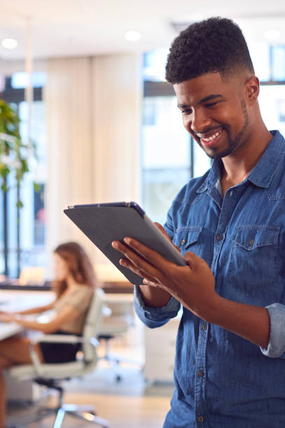 istock Young Smiling Businessman With Digital Tablet Standing And Working In Modern Office 1487502975
