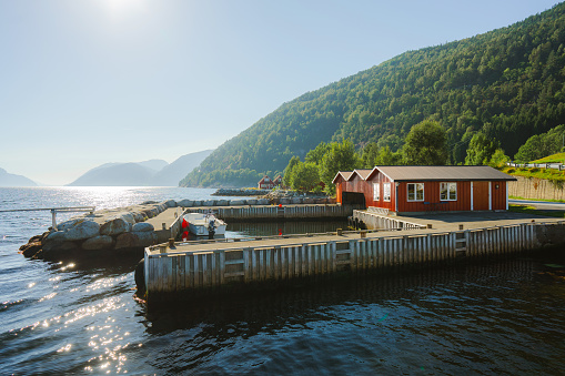 Scenic view of wooden pier and  fishing houses on fjord in Norway on sunny day