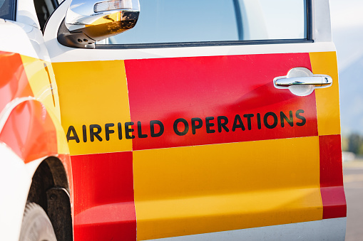 Focus on the airport vehicle for airfield operations, bright colours.