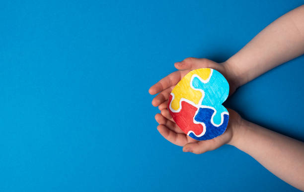 istock Child hands holding a puzzle heart on a blue background 1487506144