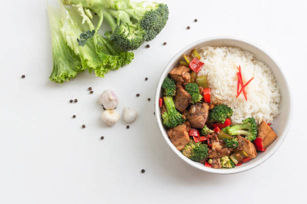 istock Stir fried chicken and broccoli bell pepper has rice in bowl on white wood table. 1487506423