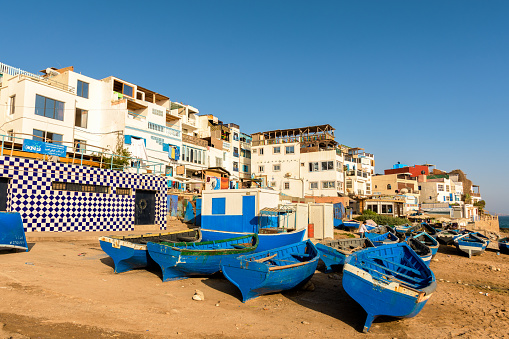 Blue wooden boats on the shore in Taghazout Village in Morocco