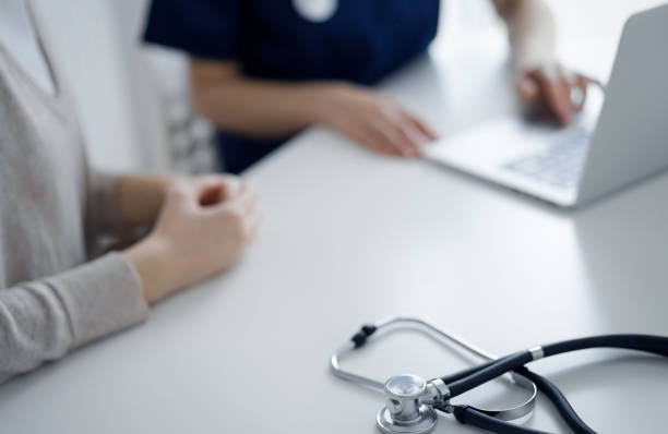istock Stethoscope lying on the tablet computer in front of a doctor and patient using laptop computer at the background. Medicine, healthcare concept 1487507087