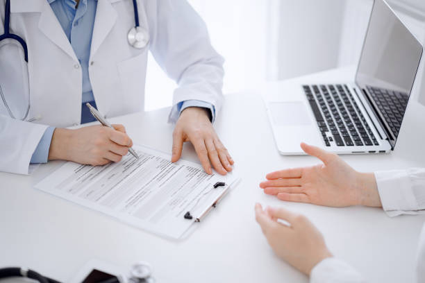 istock Doctor and patient discussing current health examination while sitting opposite each other at the desk in clinic. The focus is on female hands, close up. Medicine concept 1487507621