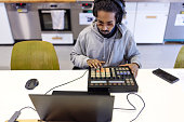 African music artist at studio making music with a midi controller