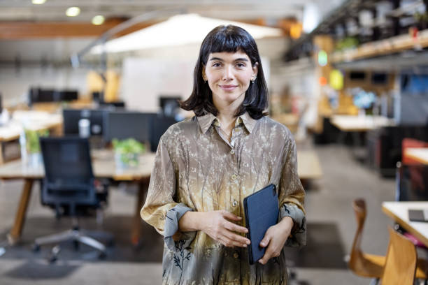 Portrait of a confident young woman standing at makers space stock photo