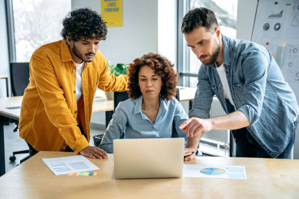 istock Teamwork, collaboration. Successful focused multiracial people, creative business team, are working together on a project in a modern office, discussing ideas, brainstorming, analyzing results 1487508290