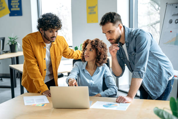 istock Teamwork, collaboration. Successful people of different nationalities, creative business team, working together on a project in a modern office, watching presentation, discussing ideas, brainstorming 1487508297
