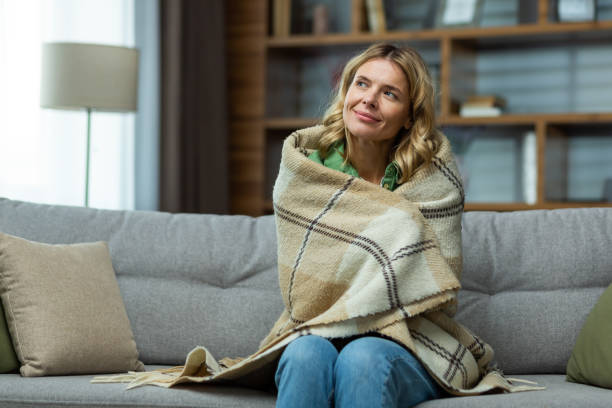 istock An elderly woman covered with a blanket sits dreamily at home on the sofa and rests 1487510355