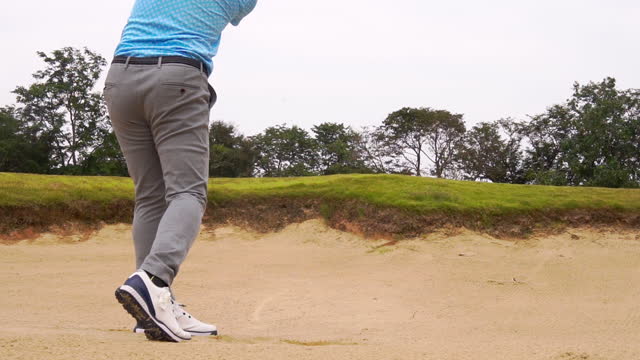 Shooting golf ball from sand bunker.