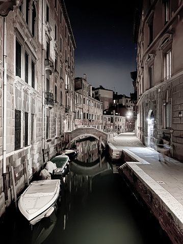 Venice at night, with its canals, boats and old mansions illuminated.