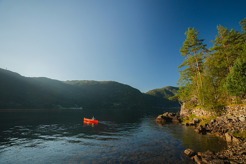 Scenic  view of young woman  canoeing on the lake in Norway