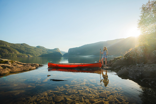 Scenic  view of young woman  canoeing on the lake in Norway