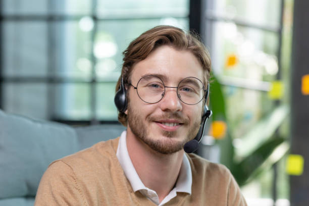 photo en gros plan. portrait d’un jeune homme portant un casque et des lunettes, souriant et regardant la caméra - customer service representative audio photos et images de collection