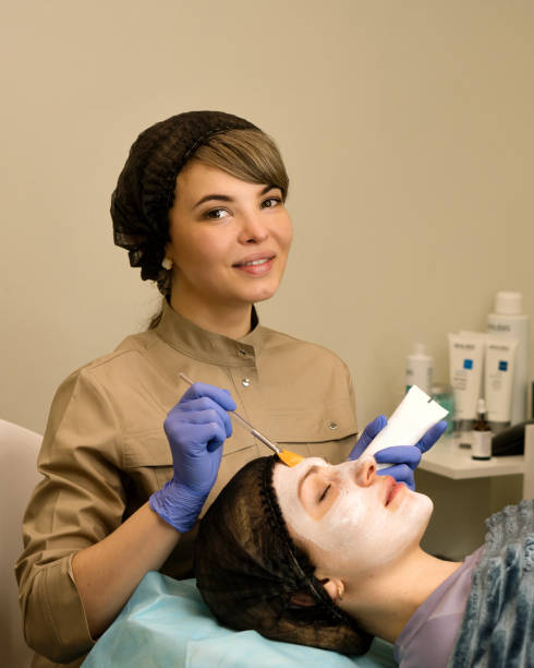 istock Cosmetologist applying anti-aging mask 1487520462