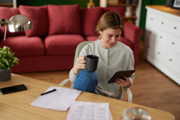 istock Women using digital tablet to check her finances at home office 1487521136