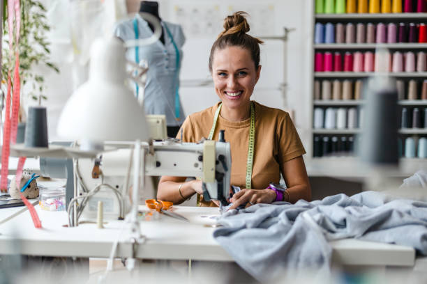 istock Fashion designer using a sewing machine at her workplace 1487521543