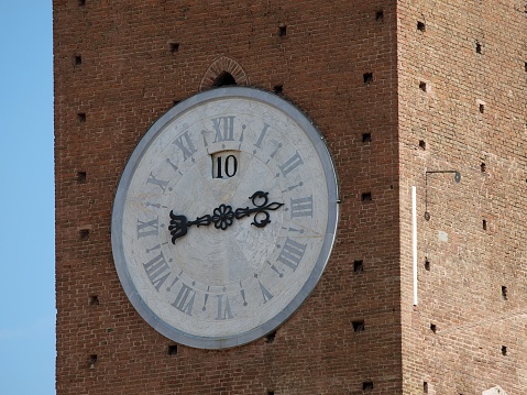 A closeup shot of the clock on the historic Torre del Mangia tower in Siena, Italy