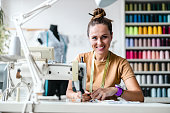 Fashion designer using a sewing machine at her workplace