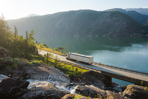 Scenic view of  truck on the road near  the waterfall that falls into fjord in Norway