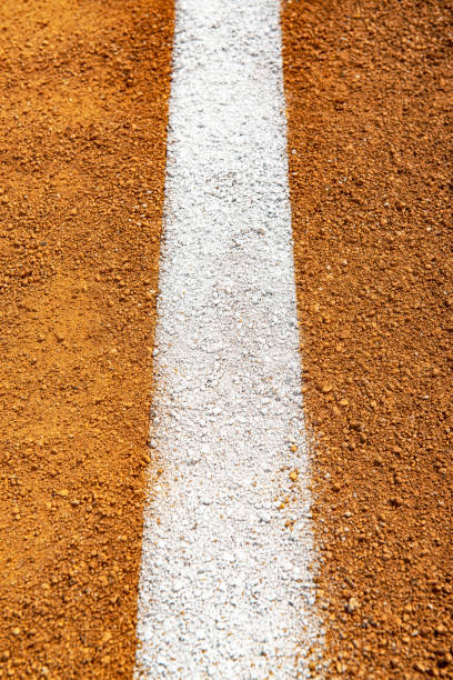 guardando dall'alto in basso una linea di fallo bianca sulla sporcizia del diamante da baseball - baseline baseball single line dirt foto e immagini stock