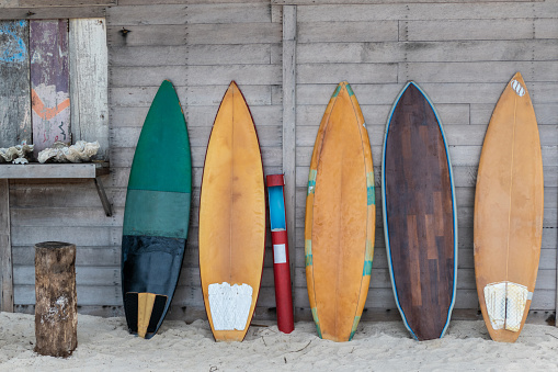 Surfboards lean on wooden wall on the beach