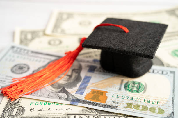 istock Graduation gap hat on Euro and US dollar banknotes money, Education study fee learning teach concept. 1487526904