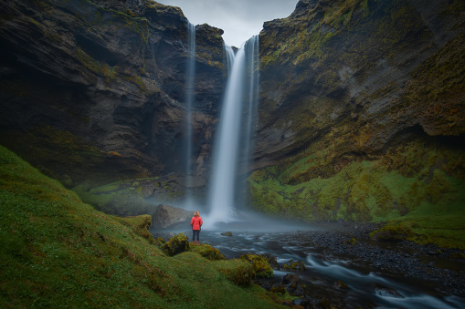 Iceland waterfall Kvernufoss hidden in a gorge Kvernugil by a river Kverna with standing girl