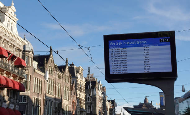 Amsterdam, Netherlands - September 28, 2022: A modern electronic display board announcing expected waiting times for bus and tram services to the central station in Amsterdam, Netherlands.