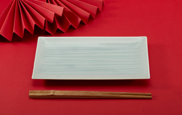 istock Chinese style chopsticks with red background and red folding fan, light green long plate and bamboo modeling 1487528704