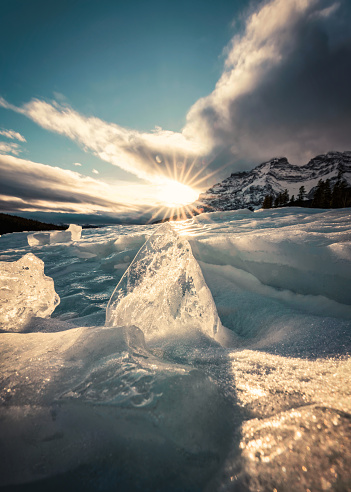 Sunset over cracked ice from frozen lake in winter season