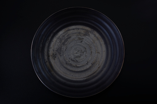 a dark grey ceramic plate with a water ripple