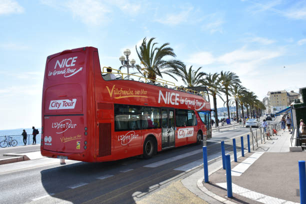 nice beach, french riviera, france europe, nice hop on hop off double decker bus, road - city of nice france french riviera promenade des anglais imagens e fotografias de stock