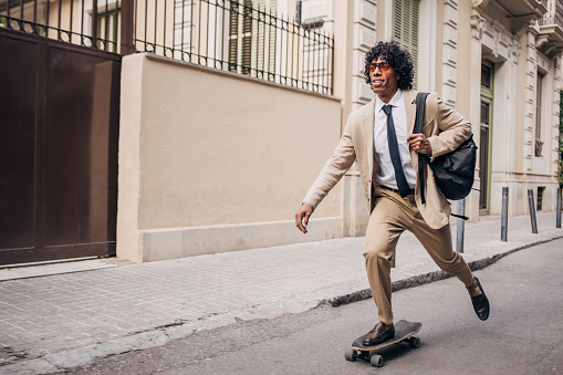 Businessman riding a skateboard while commuting to work