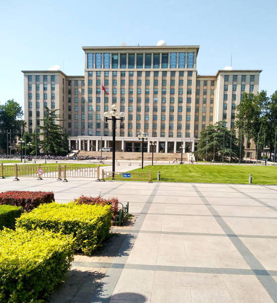 estudiantes en bicicleta frente a la entrada principal del edificio de la universidad de tsinghua en beijing, china - tsinghua fotografías e imágenes de stock